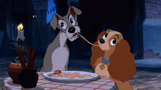 Two dogs kiss as they eat the same piece of spaghetti in Lady and the Tramp.